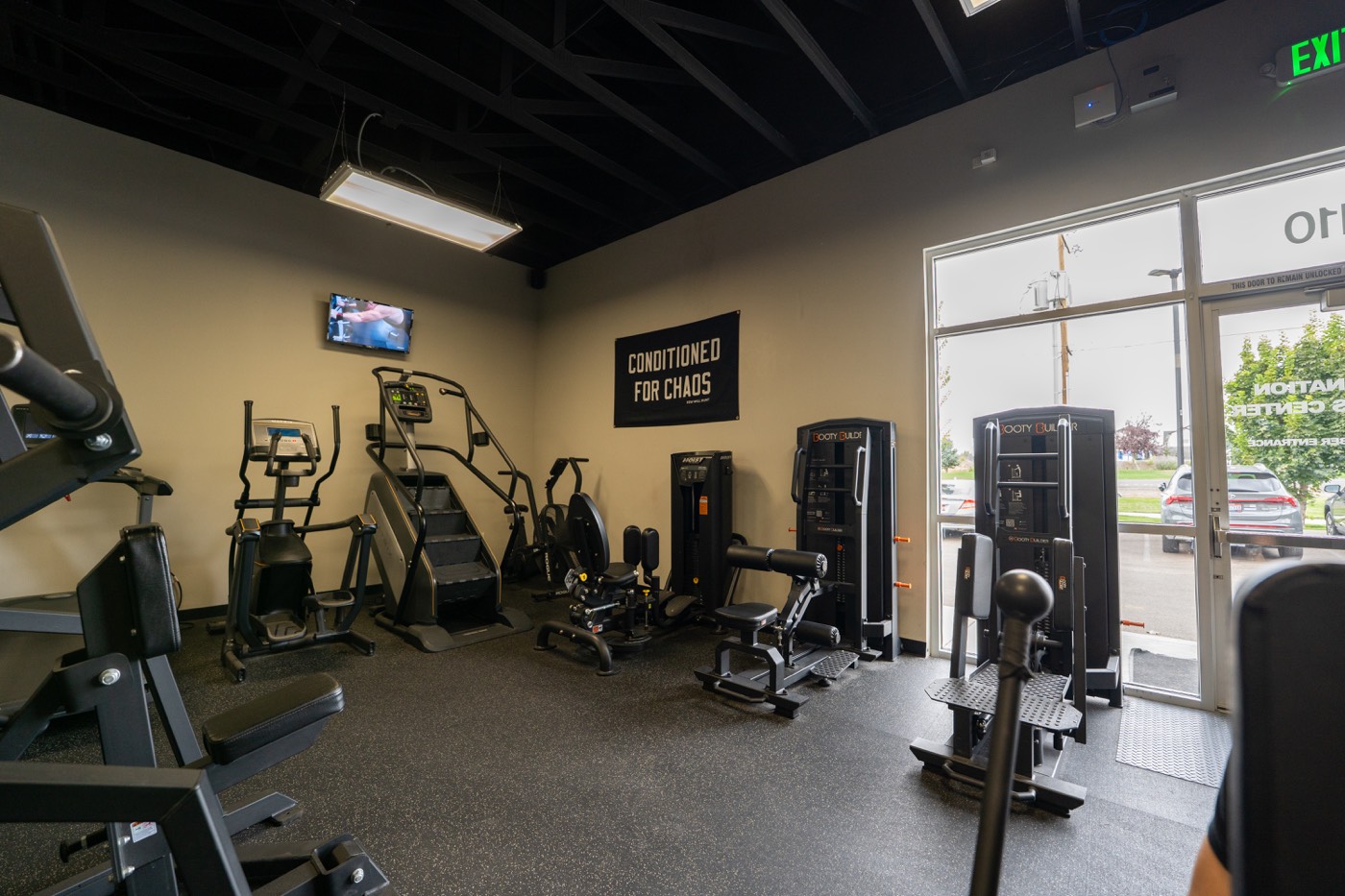 Cardio and strength equipment by the front windows
