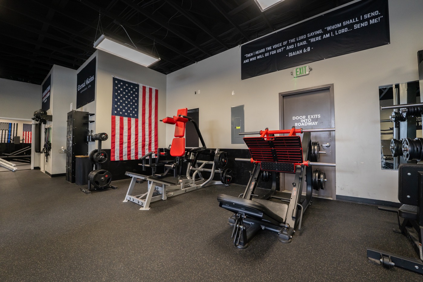 Squat racks and benches in front of the flag wall
